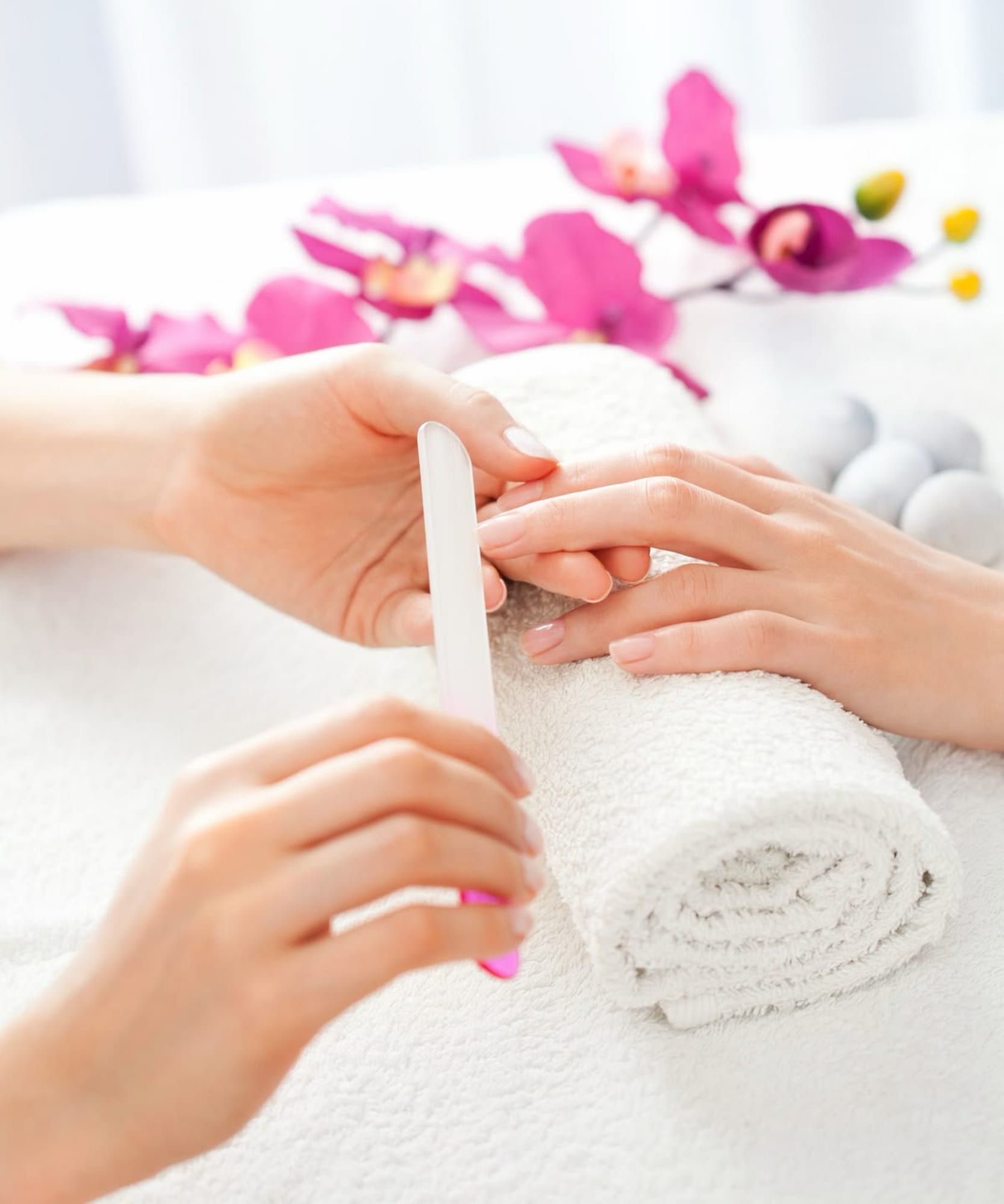 Klassische Maniküre – Nageltechnikerin feilt die Nägel